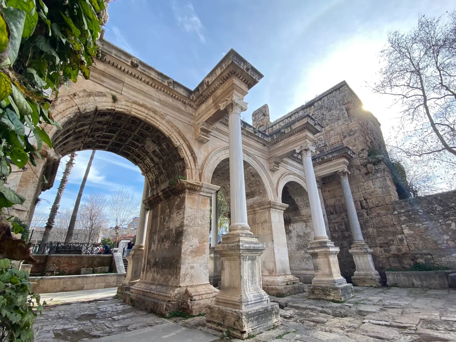 The three marble arches and columns of Hadrian's Gate at the edge of Kaleiçi, seen from below on the stone paving