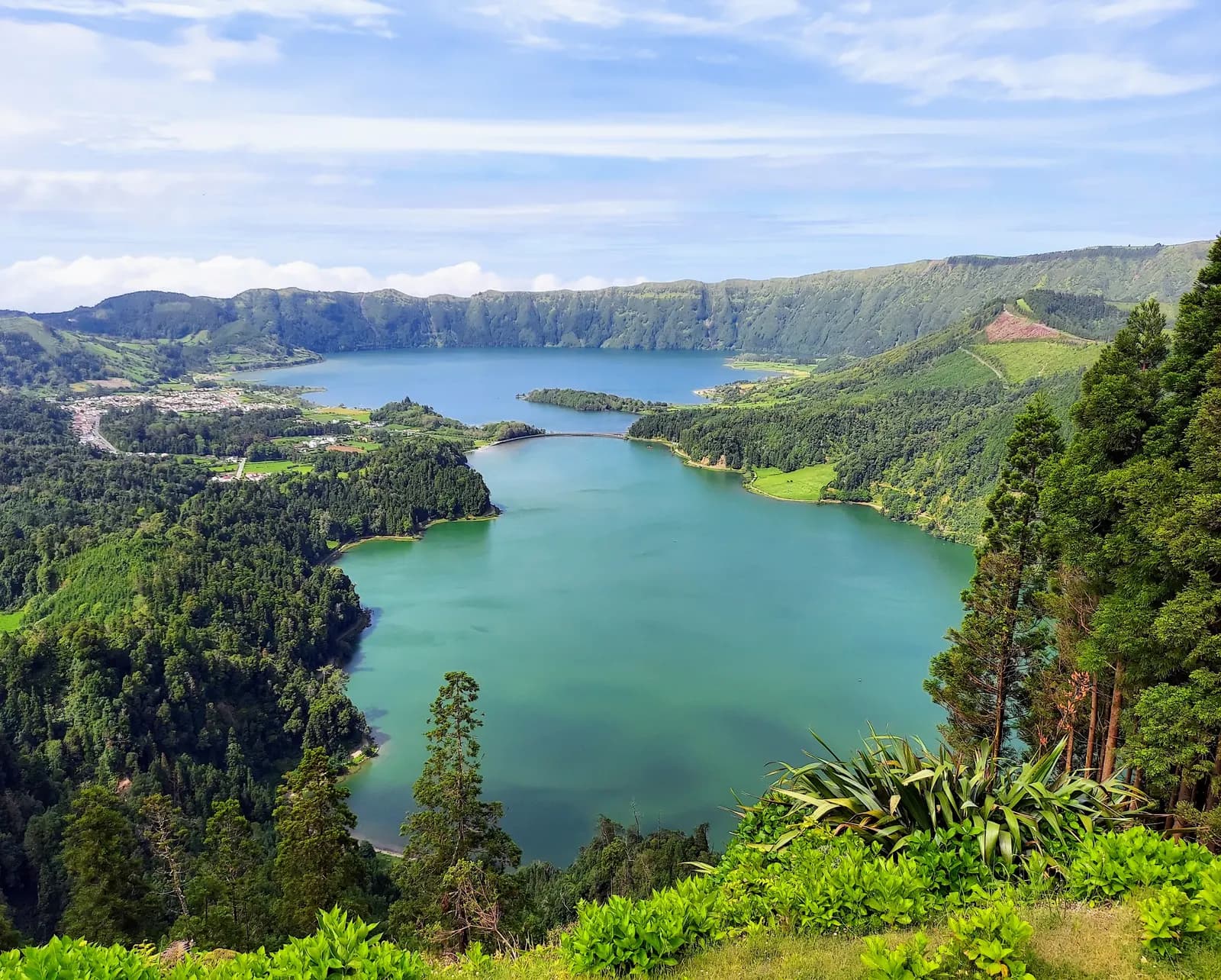 The green Lagoa Verde and the blue Lagoa Azul inside the Sete Cidades crater, seen from the Vista do Rei viewpoint with forest and fields around