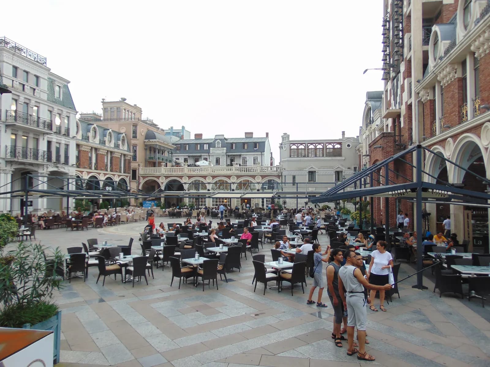 Café tables on the Piazza in Old Batumi, a paved square surrounded by buildings with balconies and arcades