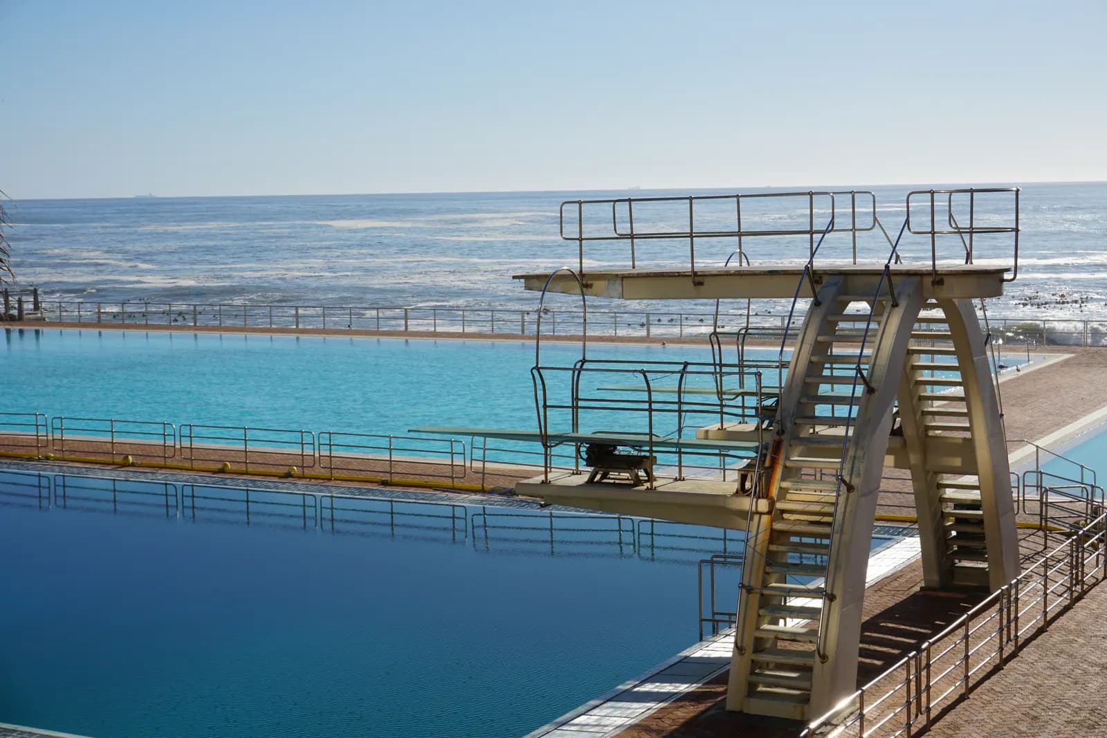 The diving tower and outdoor pools of the Sea Point Pavilion, with the Atlantic Ocean behind