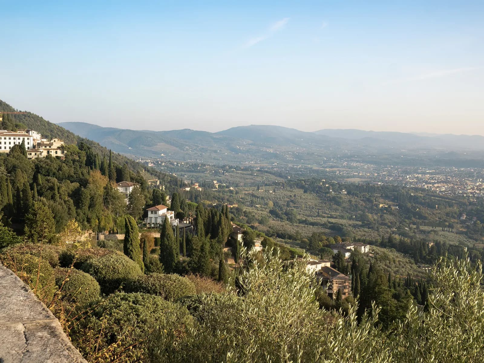 Villas, cypresses and olive trees on the hillside below Fiesole, looking out over the valley.