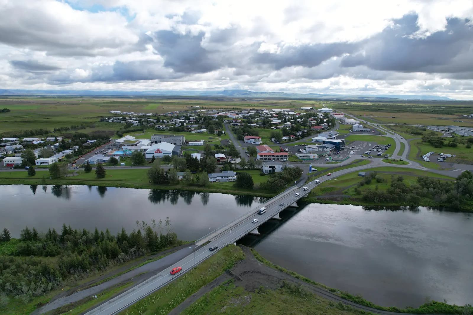 Aerial view of Hella on the Ytri-Rangá river, with the road bridge in the foreground and the town and flat farmland behind