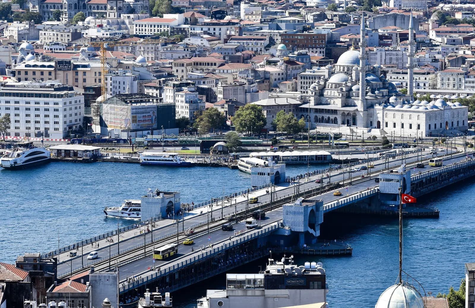 The Galata Bridge seen from Galata Tower, with ferries at the piers on the far shore and a domed mosque with minarets behind