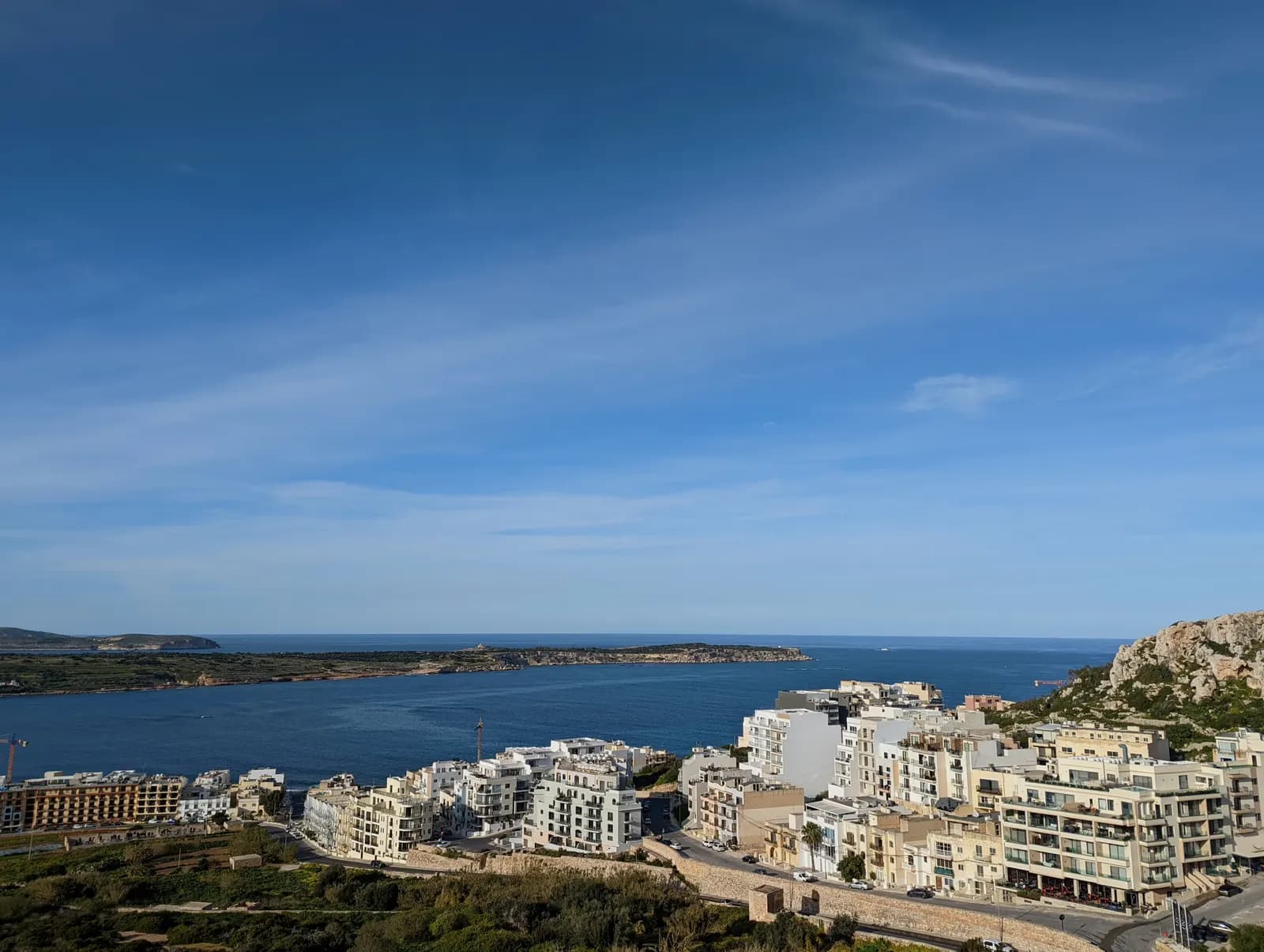 Apartment blocks on the slope of Mellieħa above Mellieħa Bay, with the Marfa ridge across the water