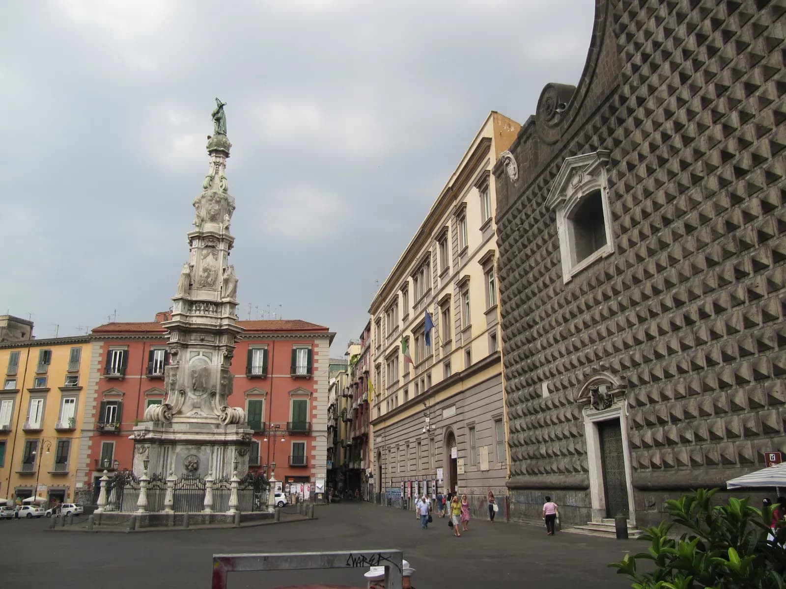 Piazza del Gesù Nuovo in Naples, with the carved spire of the Guglia dell'Immacolata and the diamond-point stone front of the Gesù Nuovo church.