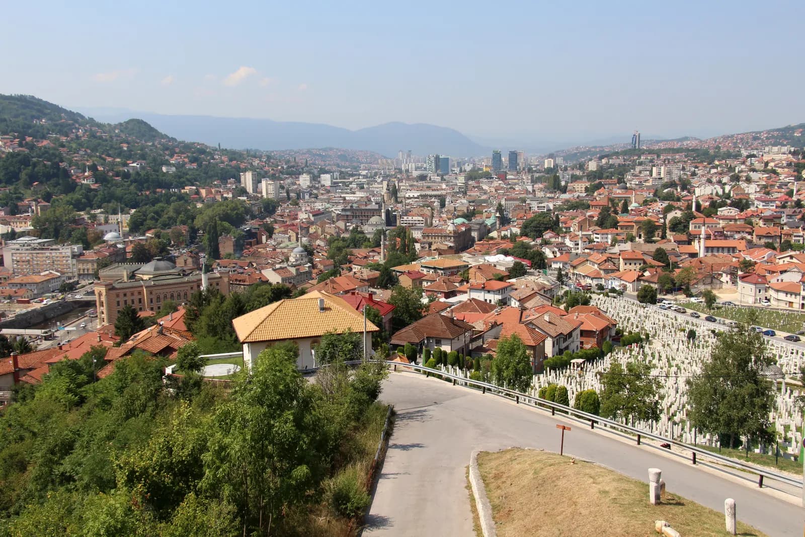 Sarajevo seen from the Yellow Fortress on Vratnik: red roofs down the hillside, the city along the valley and mountains on the horizon