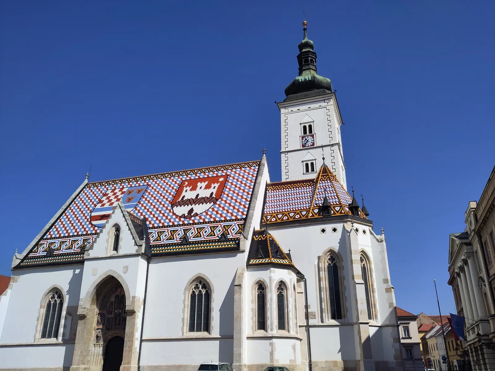 St Mark's church in Zagreb's Upper Town, with its patterned tiled roof showing two coats of arms and a white bell tower