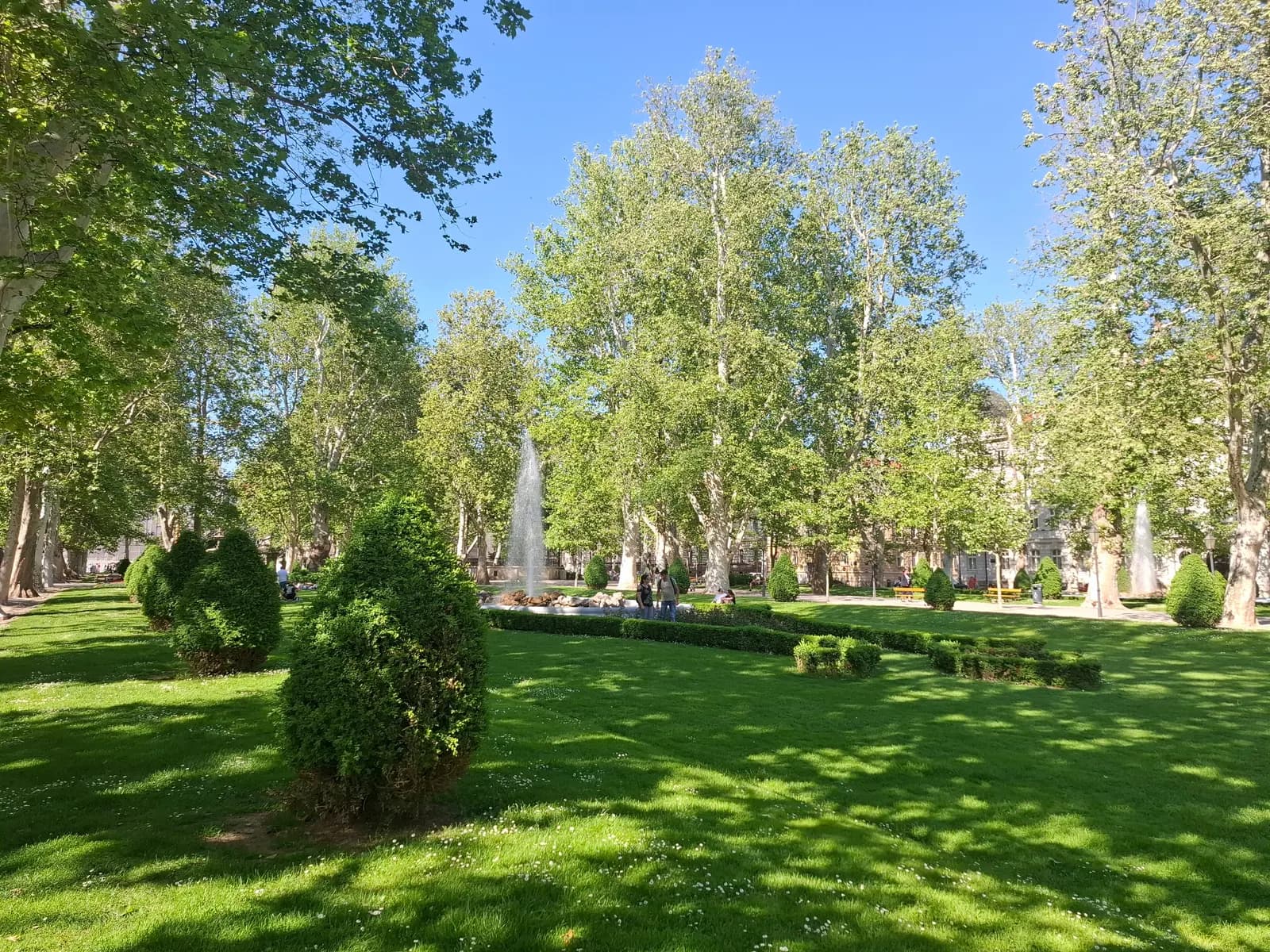 Zrinjevac park in Zagreb's Lower Town, with plane trees, clipped shrubs, lawns and a fountain in spring