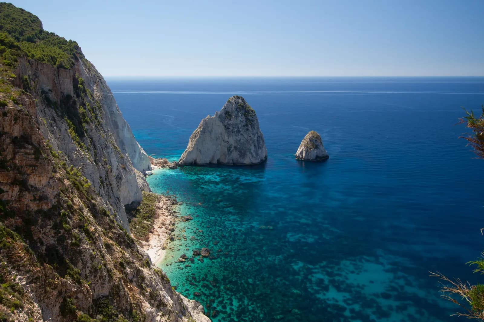 The Mizithres sea stacks off the cliffs of Cape Keri in the south west of Zakynthos, above clear turquoise and deep blue water