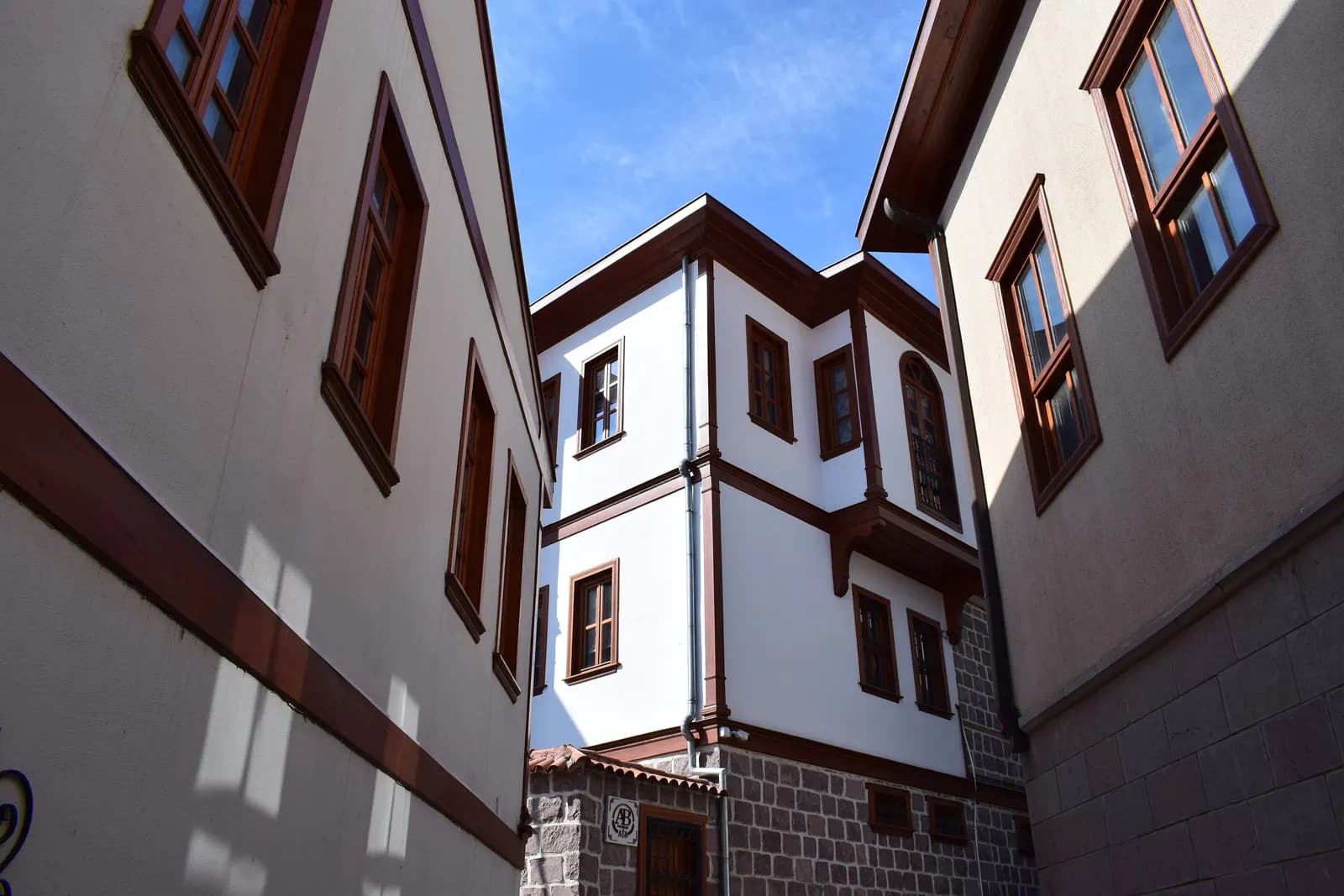 White and brown houses with wooden window frames in a narrow street of Hamamönü