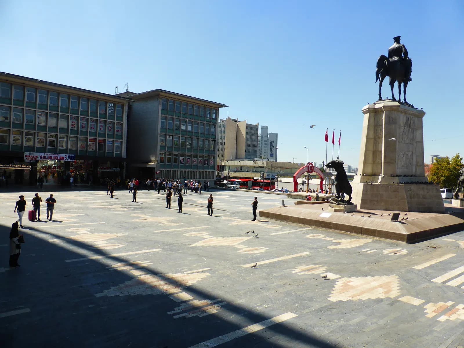 Ulus Square in Ankara on a sunny day, with the equestrian statue on its stone pedestal and office blocks behind the paved square