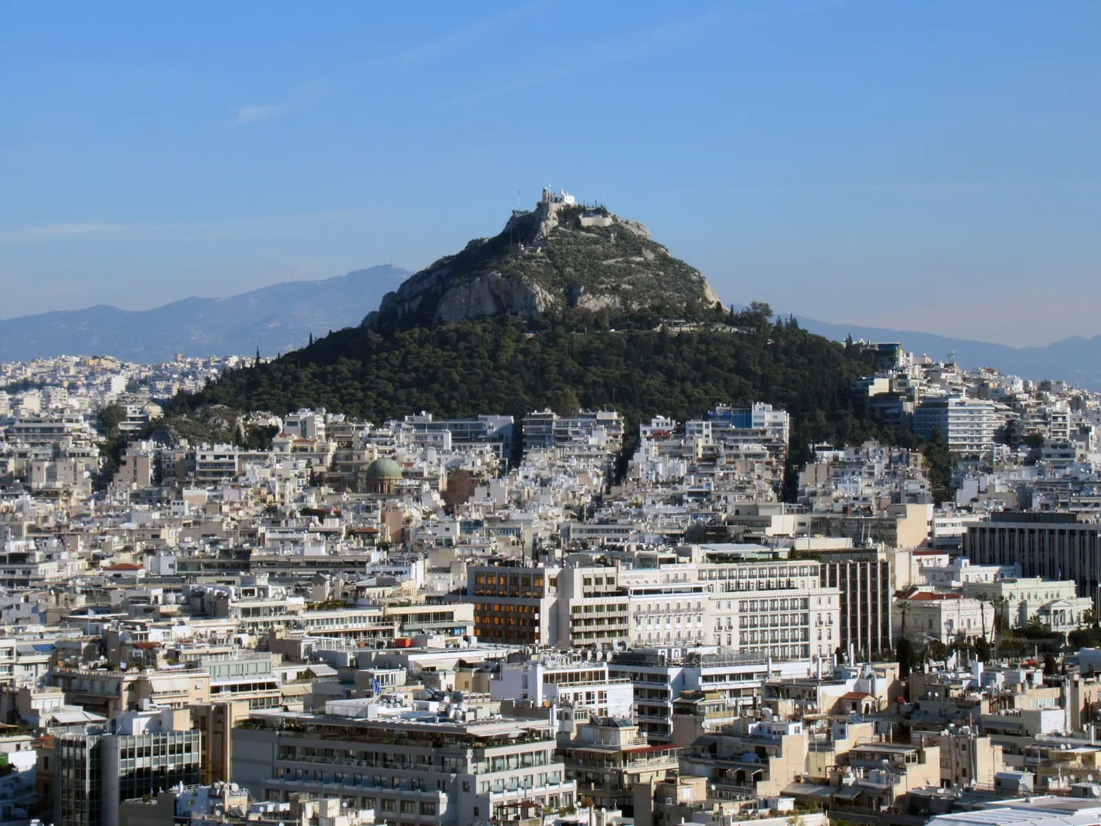 Apartment blocks of central Athens and Kolonaki spreading up to the wooded slopes of Mount Lycabettus, seen from the Acropolis