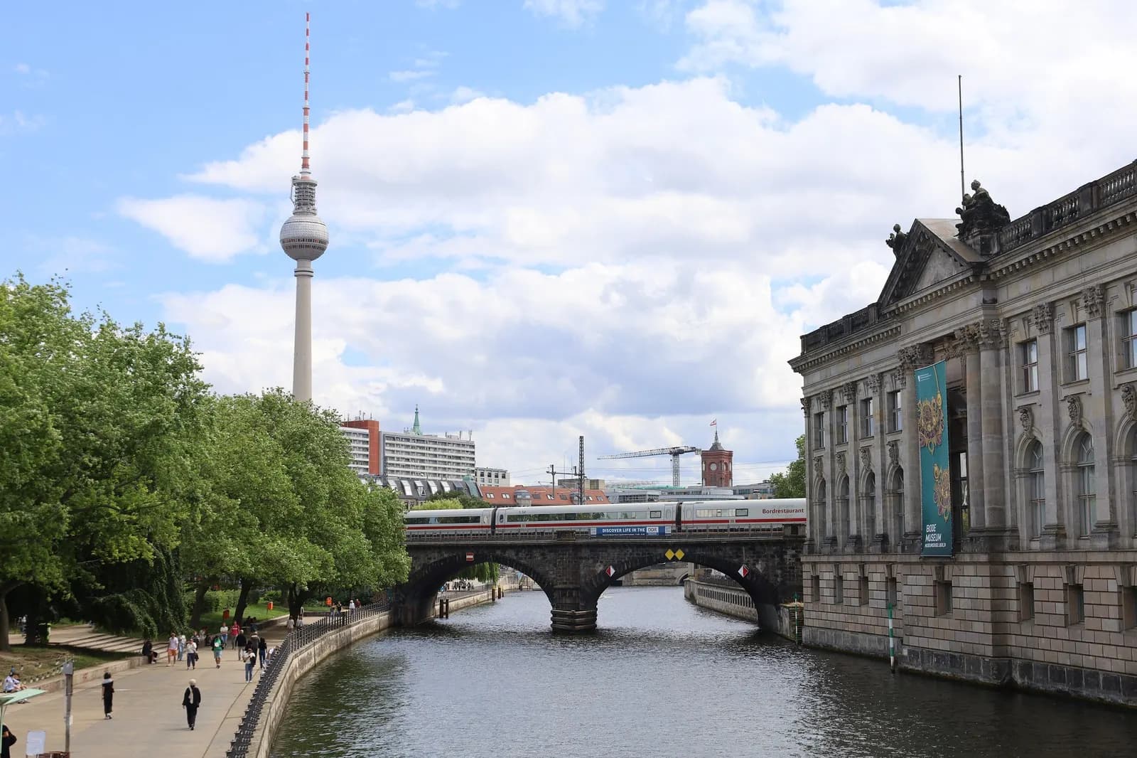 The Spree beside the Bode-Museum on Museum Island, with an ICE train crossing the Stadtbahn bridge, the Fernsehturm and the Rotes Rathaus behind