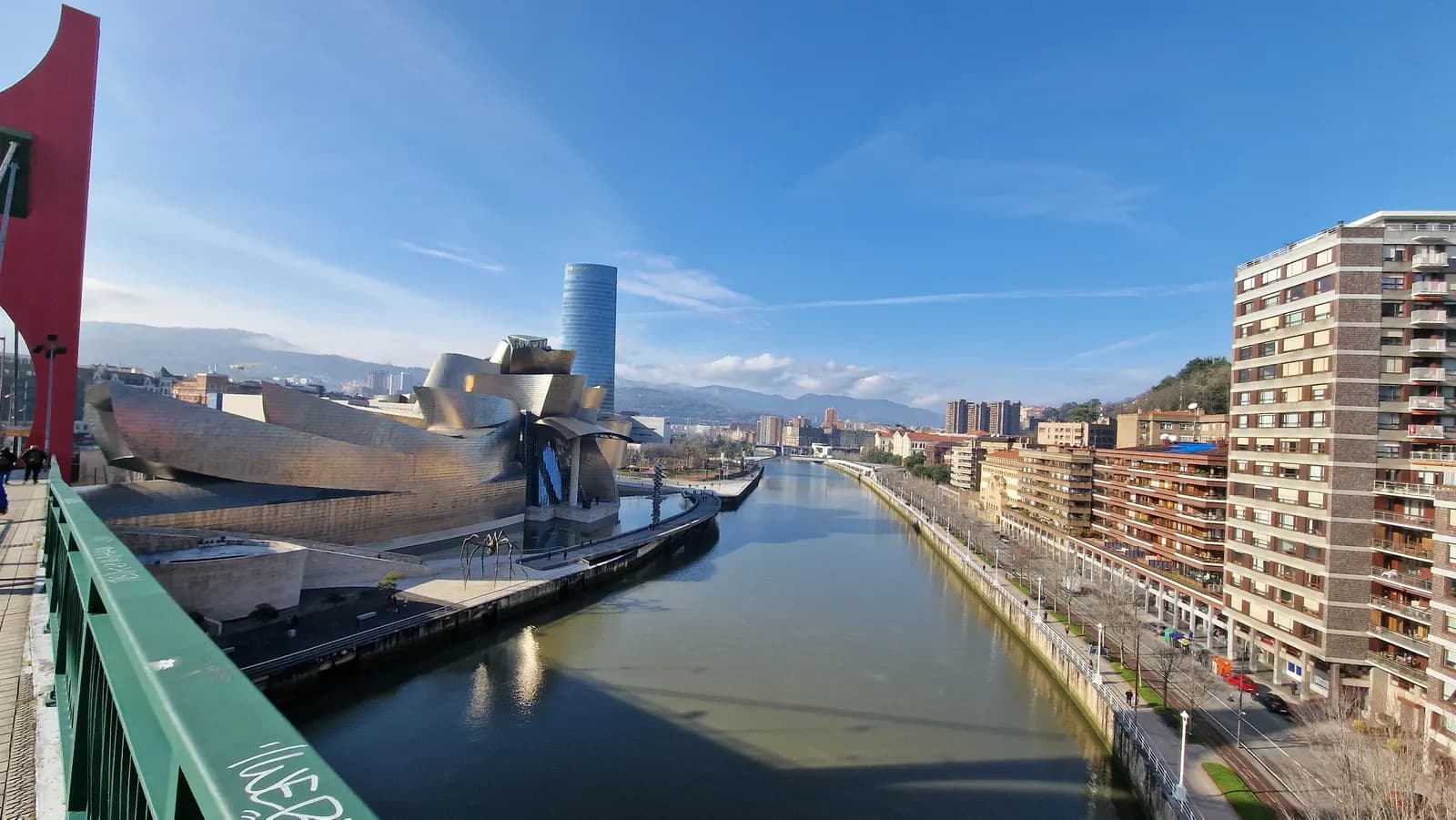 The Bilbao estuary seen from the La Salve bridge, with the titanium curves of the Guggenheim Museum on one bank and apartment blocks along the other.