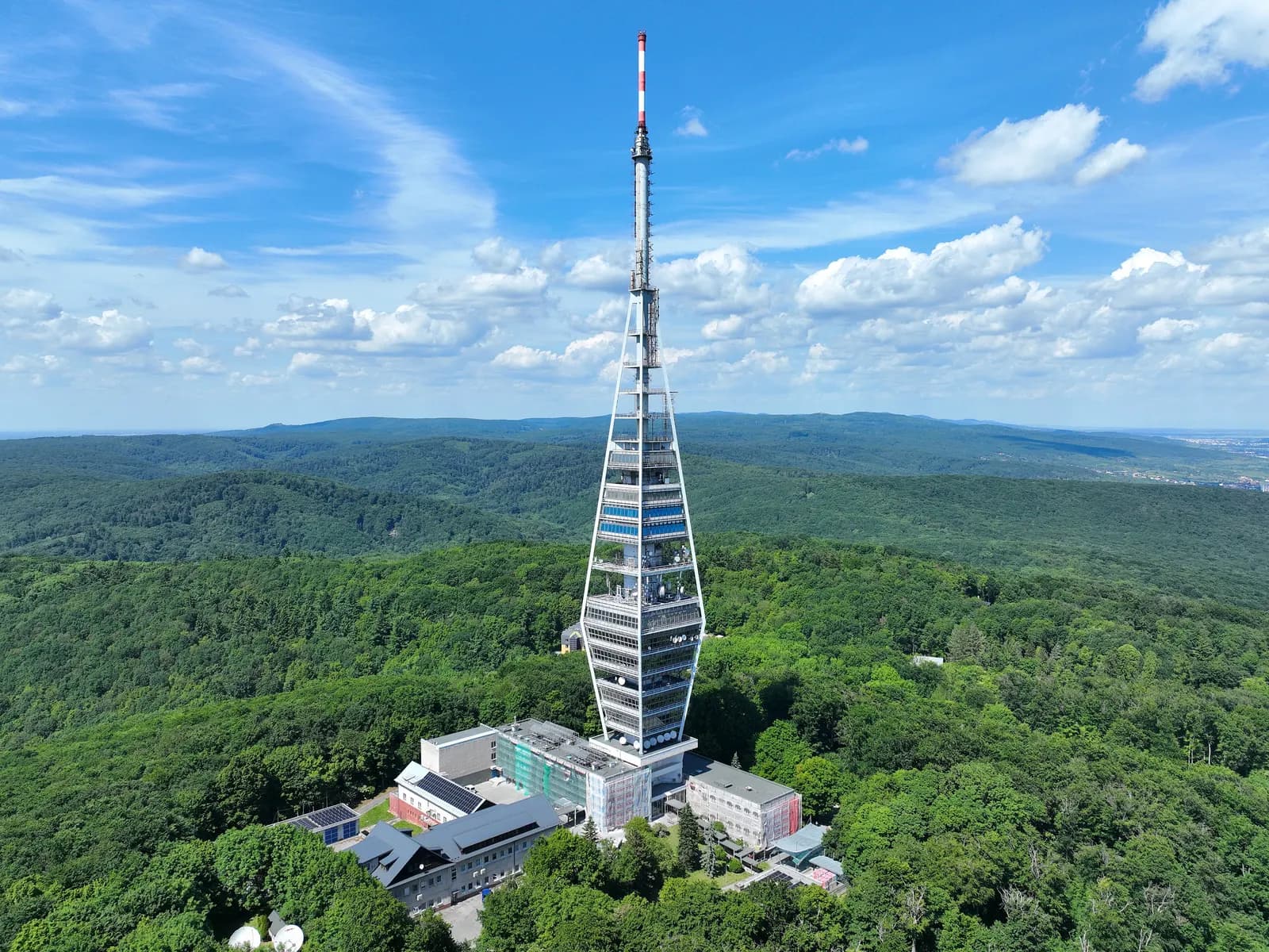 The Kamzík television tower above the forested hills of Bratislava, seen from the air on a sunny day
