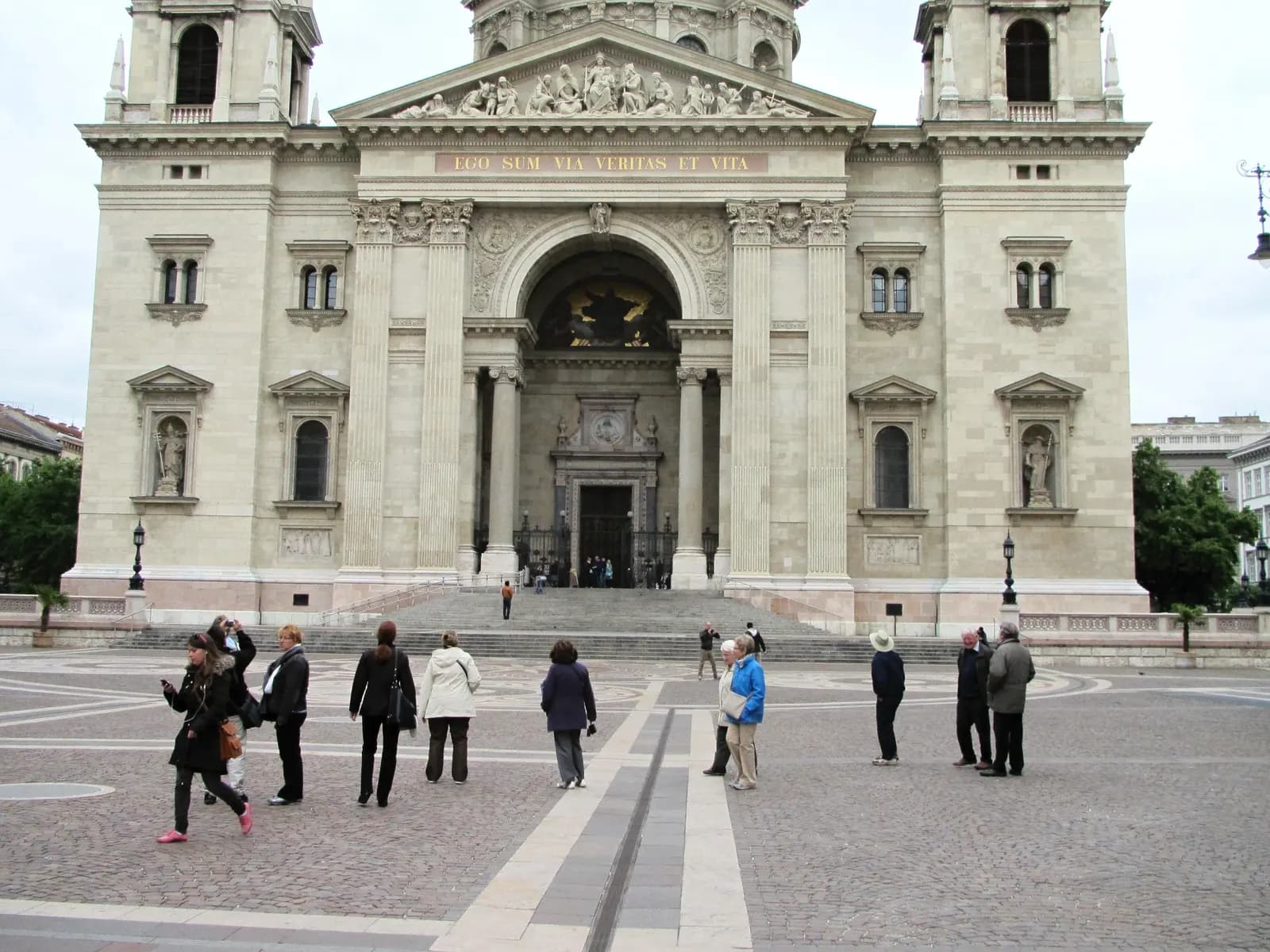 The front of St. Stephen's Basilica with its portico and two towers, seen across the paved Szent István tér with visitors walking