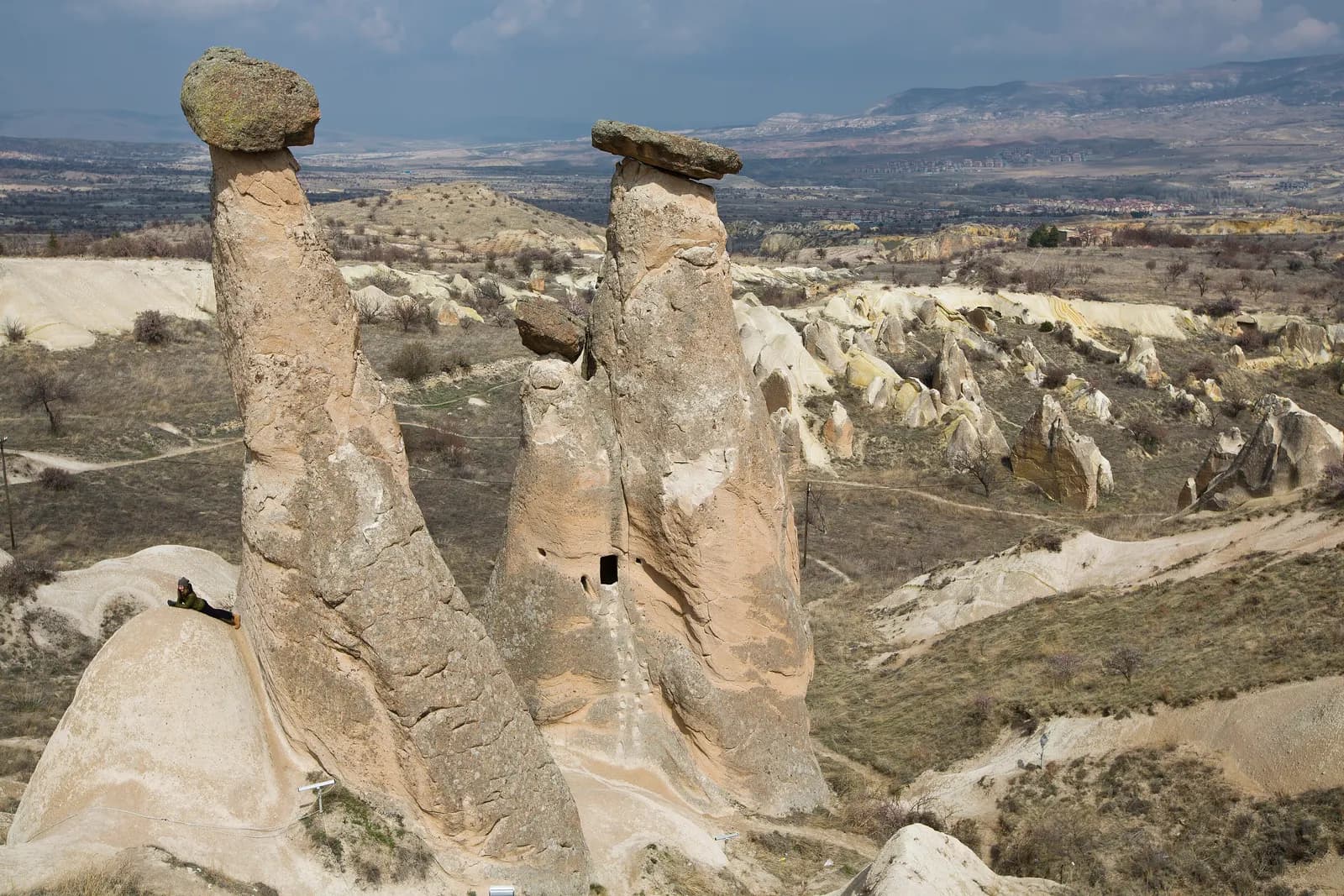 The capped rock pillars known as the Three Beauties of Ürgüp, above a valley of eroded rock and fields