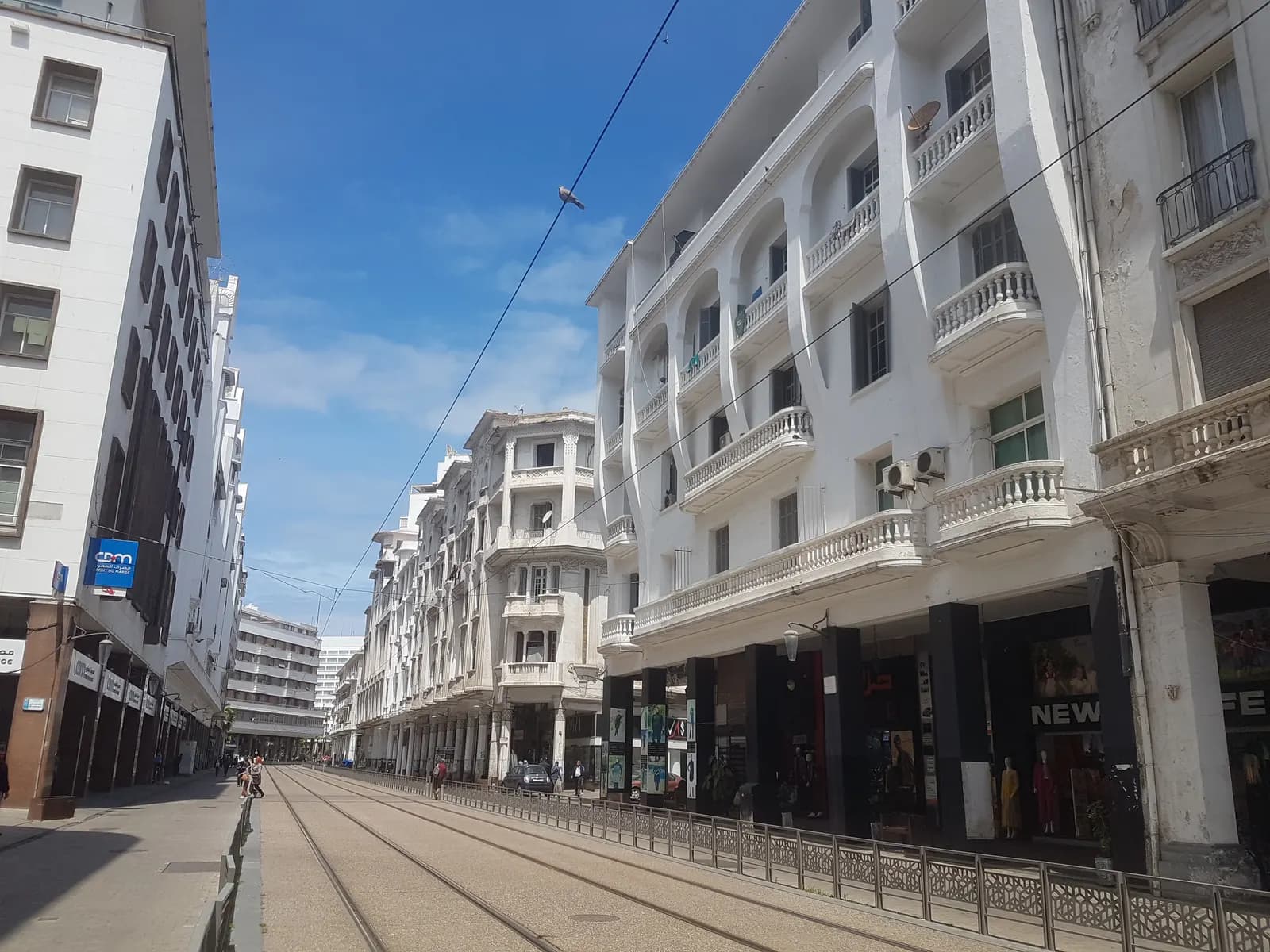 Boulevard Mohammed V in central Casablanca, with white early 20th century buildings, balconies and arcades along the tram tracks