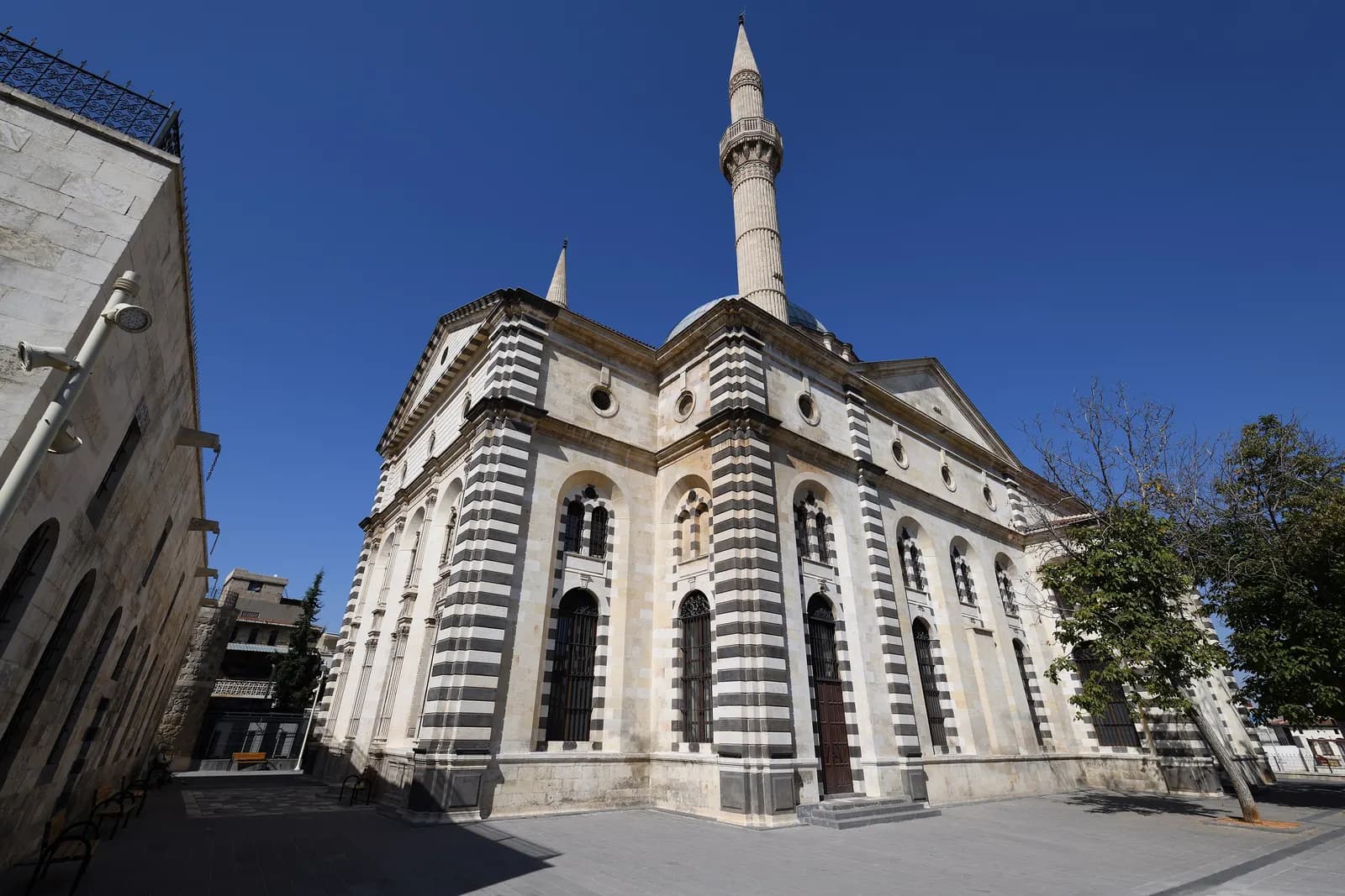 The Kurtuluş Mosque in Gaziantep, with striped black and white stone walls and a tall minaret