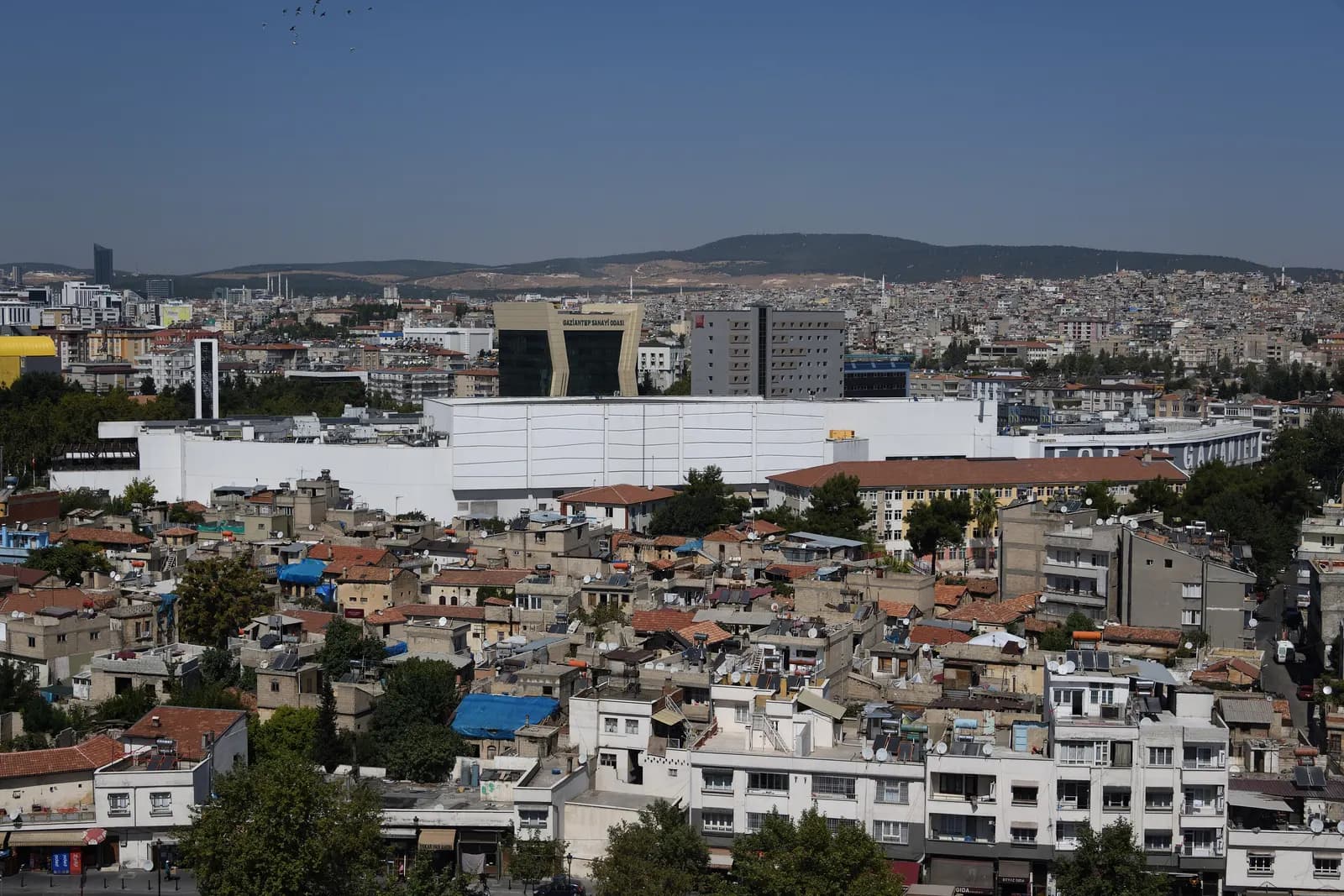 Gaziantep seen from the castle hill, with low houses in the foreground and larger buildings and hills behind