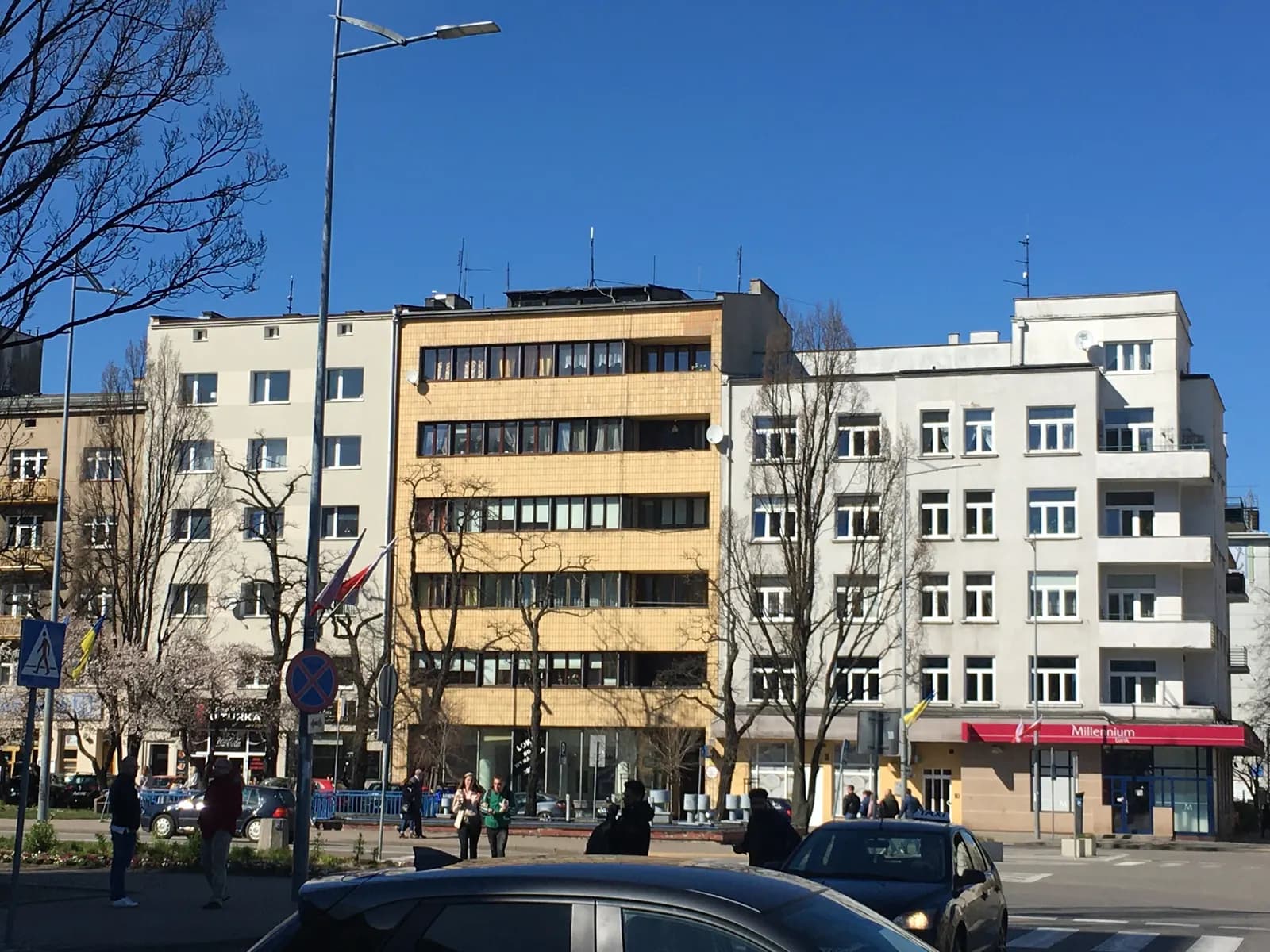 Modernist apartment and office buildings with long rows of windows on Skwer Kościuszki in central Gdynia, with bare trees in early spring