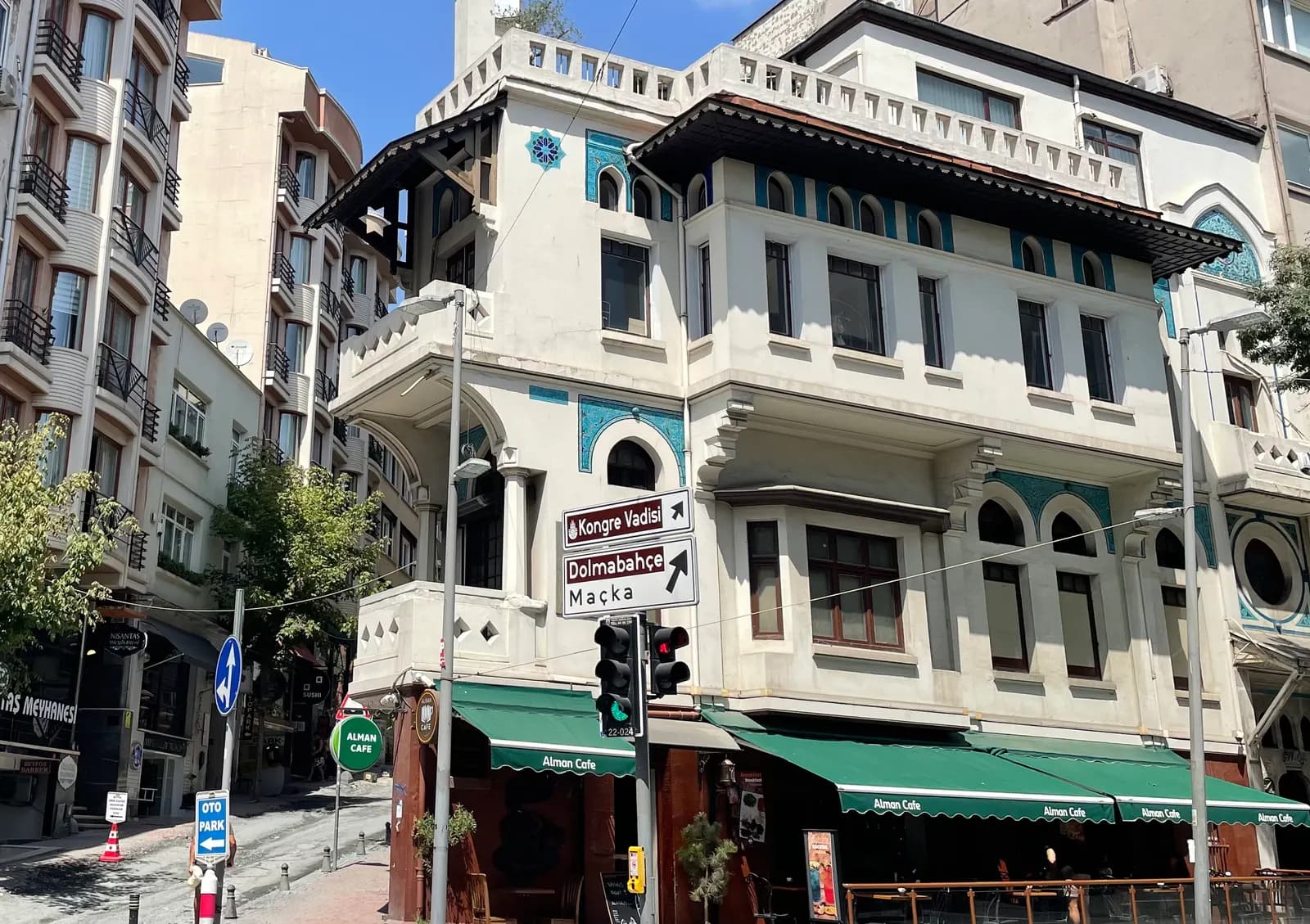 The white house of the architect Vedat Tek on Valikonağı Caddesi in Nişantaşı, with a café on the ground floor and road signs for Maçka and Dolmabahçe