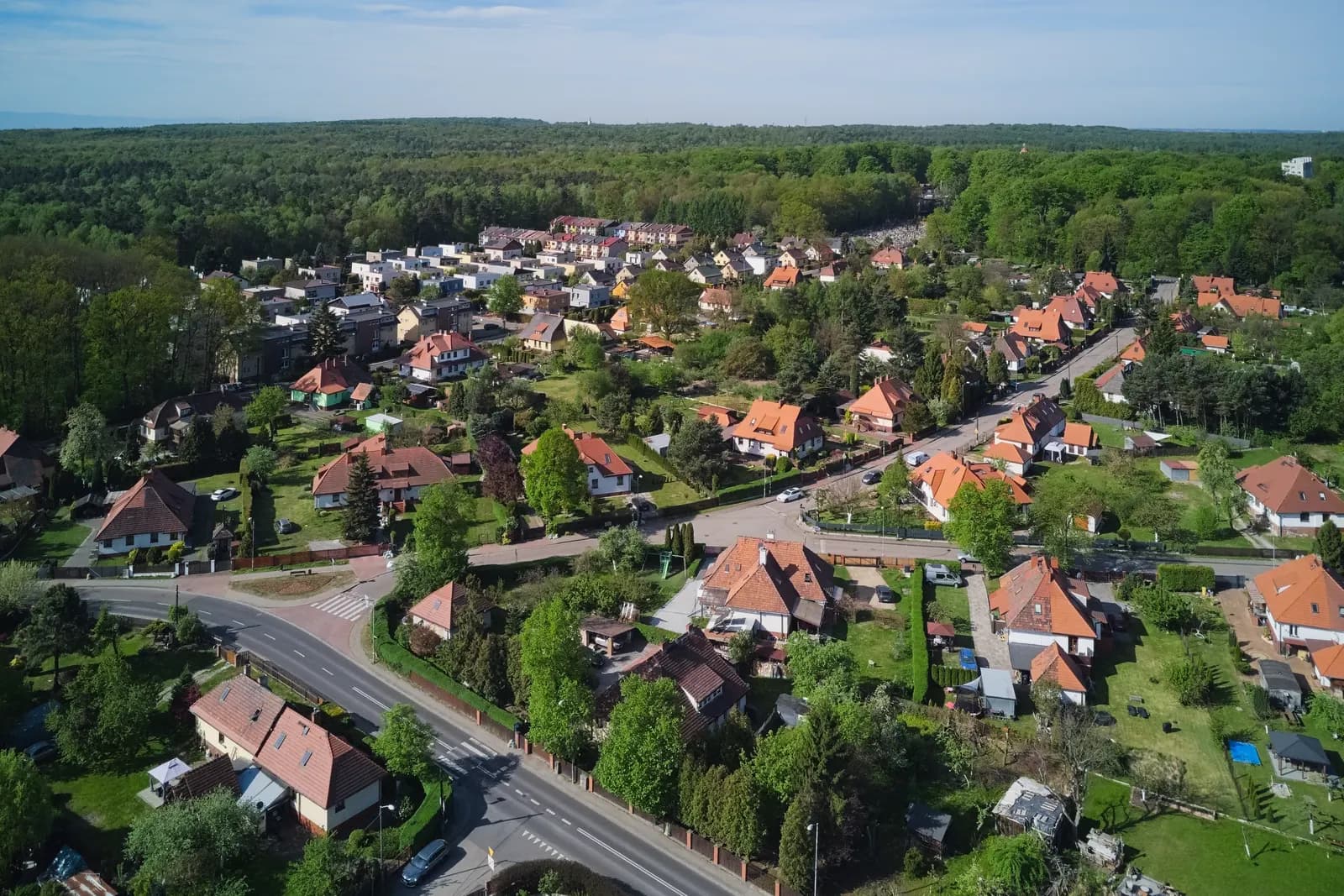 Giszowiec in Katowice seen from above: small houses with red roofs and gardens along streets, surrounded by forest