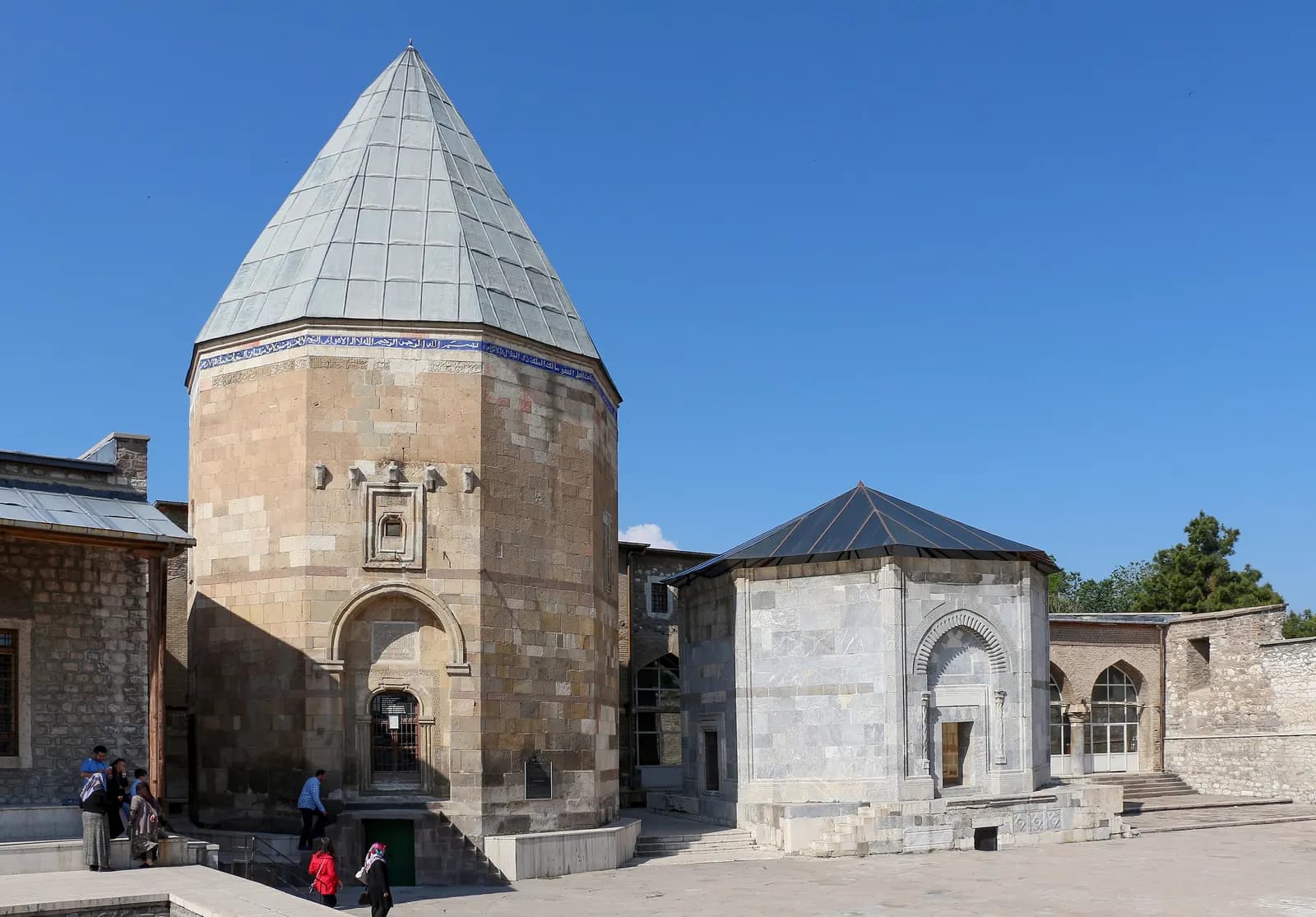Two Seljuk tombs in the courtyard of the Alaeddin Mosque in Konya, one with a tall stone drum and a pyramid roof, one in white marble