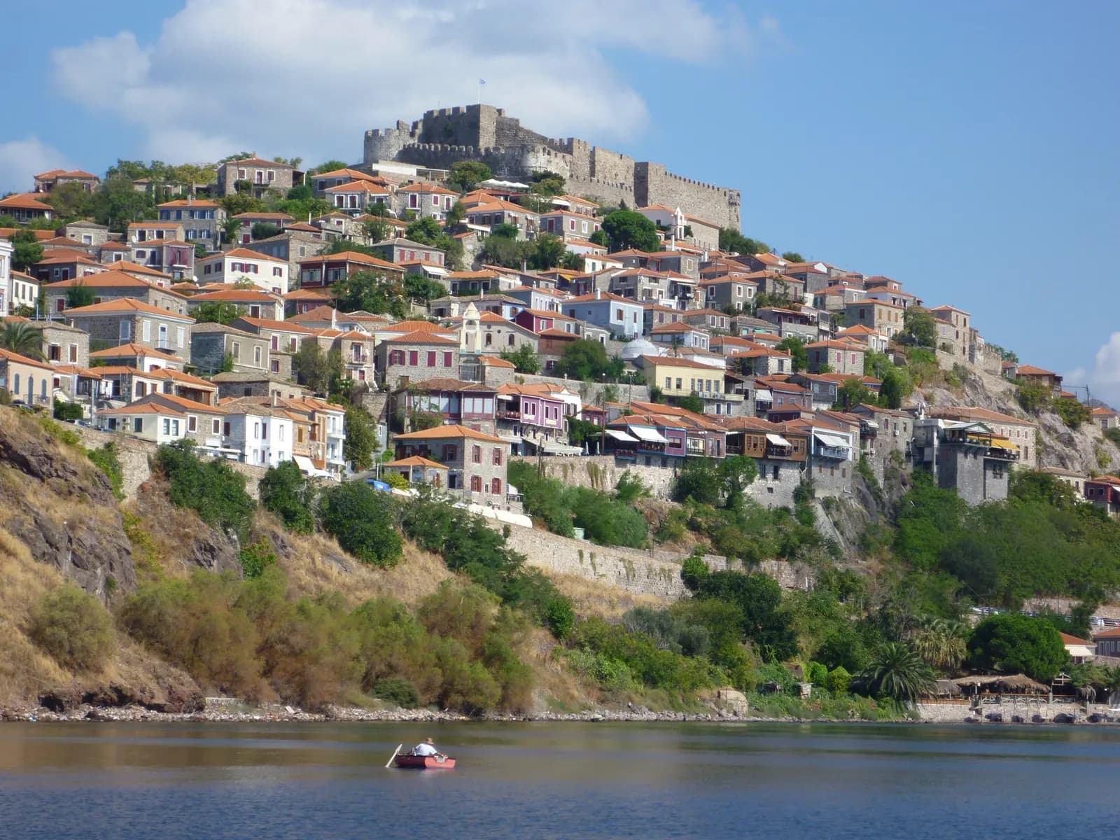 The stone and tiled houses of Molyvos climbing the hill to the castle, seen from the sea