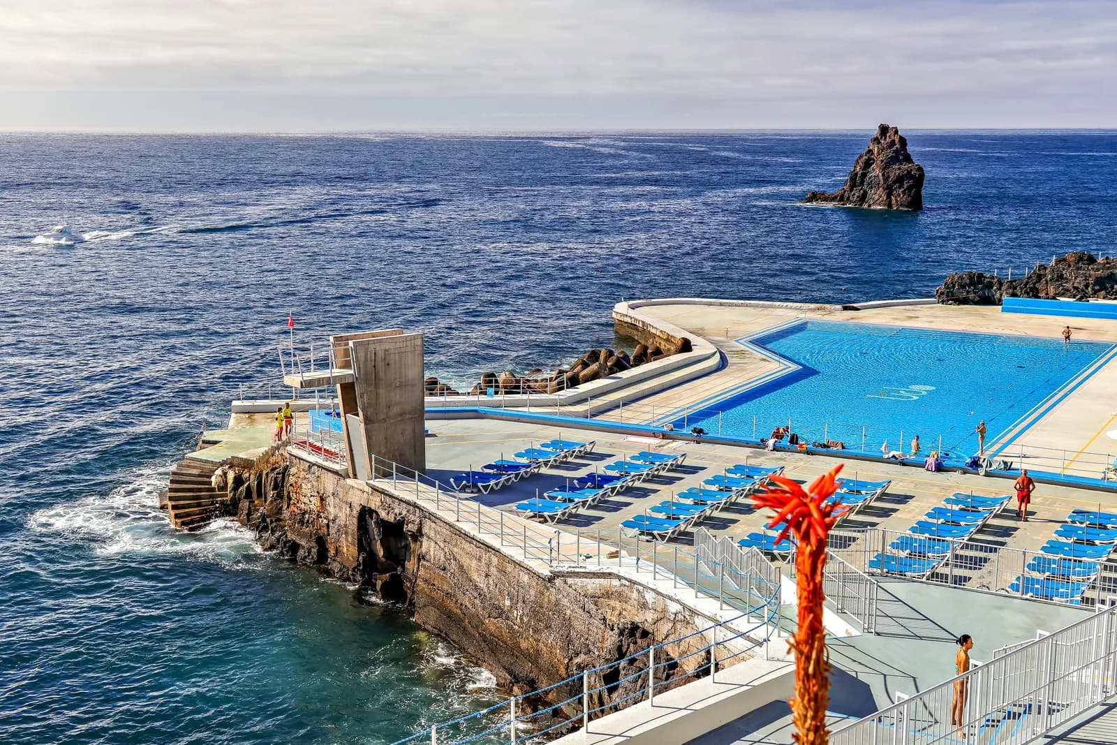 The Lido bathing complex in Funchal, a seawater pool and sun terraces on the rocky shore, with the Gorgulho rock standing in the sea