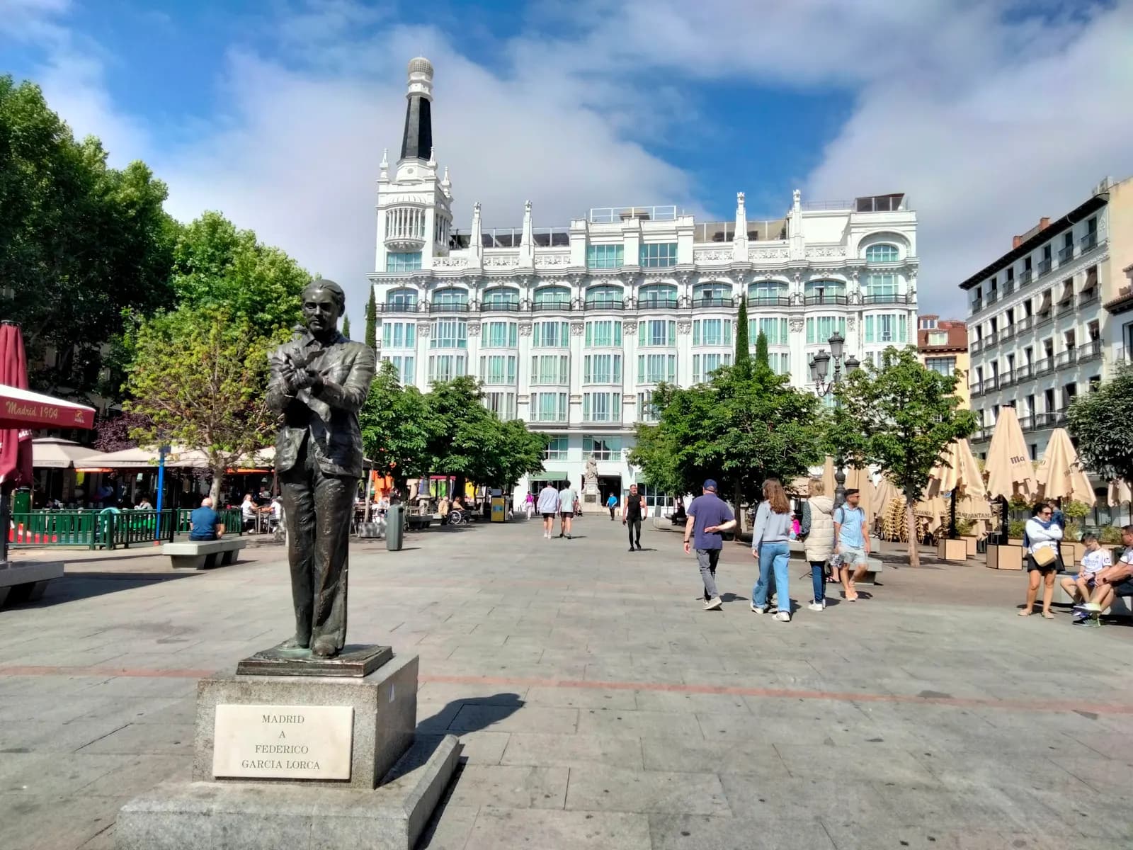 Plaza de Santa Ana in the Barrio de las Letras, with the bronze statue of Federico García Lorca, café terraces and the white Reina Victoria hotel.