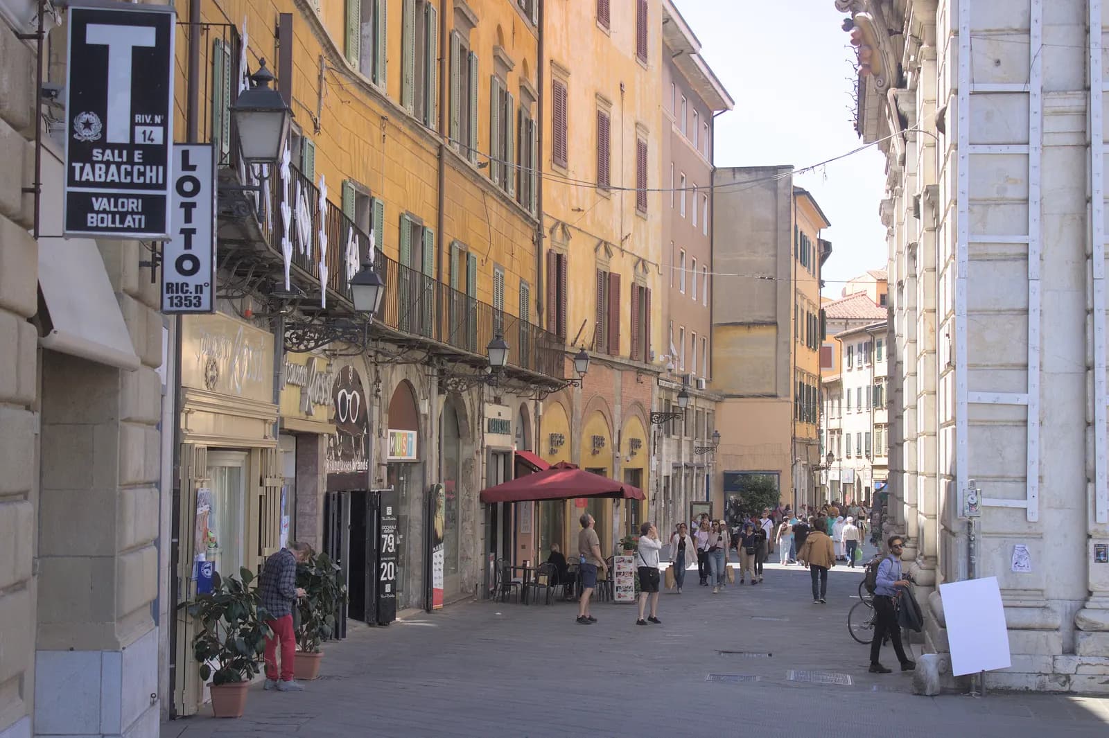 Corso Italia, the pedestrian shopping street between the Arno and the station, with ochre palazzi, shop signs and walkers.