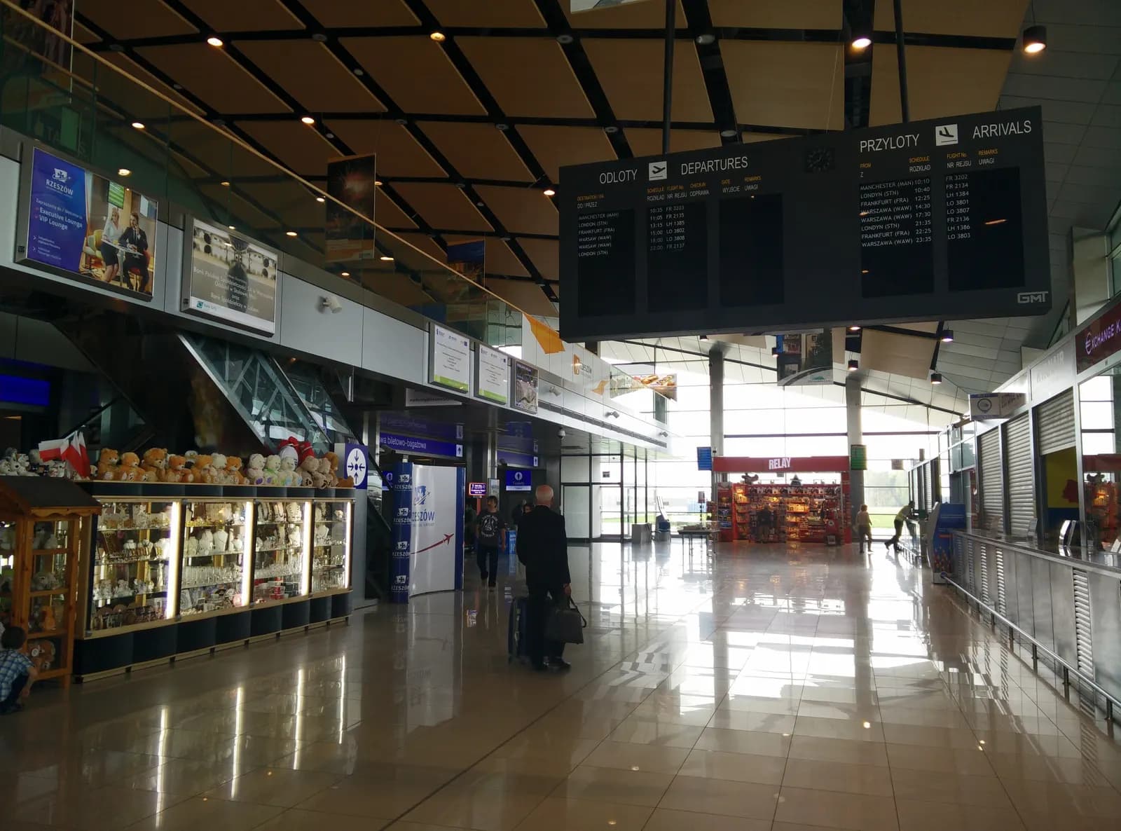 The departures hall of Rzeszów-Jasionka Airport with a departures and arrivals board, shop counters and a polished floor