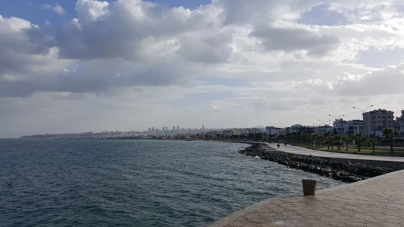 The Atakum seafront promenade and rock breakwater, with apartment blocks along the shore and the city in the distance