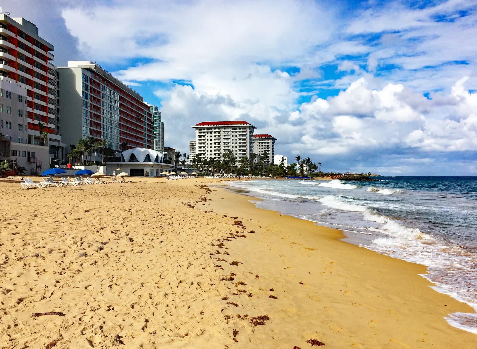 Condado beach in San Juan, with golden sand, breaking waves and high-rise hotels along the shore