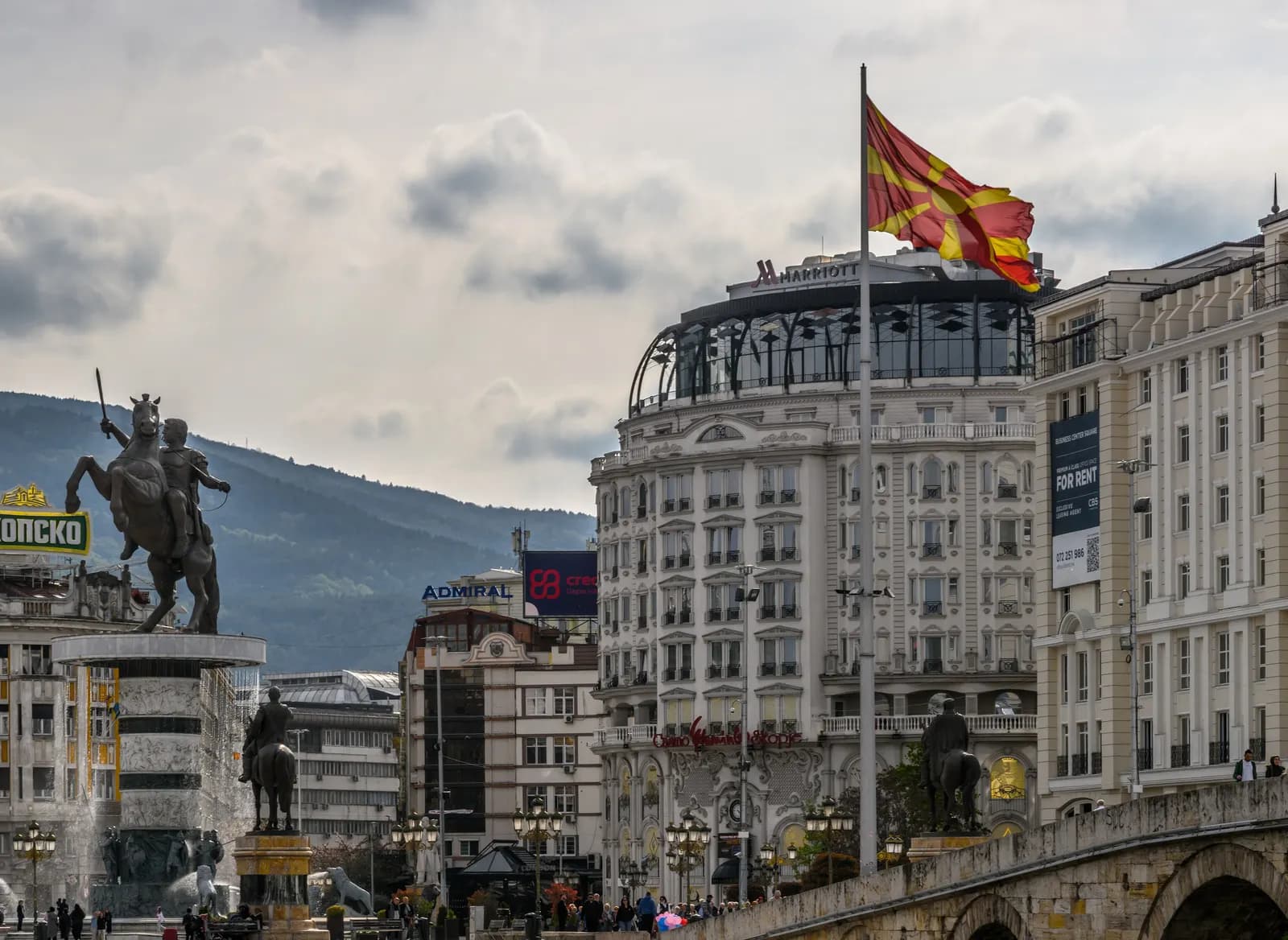 The north side of Macedonia Square in Skopje, with the warrior on horseback statue, a large flag and a domed hotel building