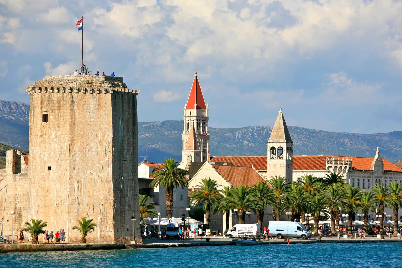 Kamerlengo fortress tower and the bell towers of Trogir old town above the palm-lined waterfront