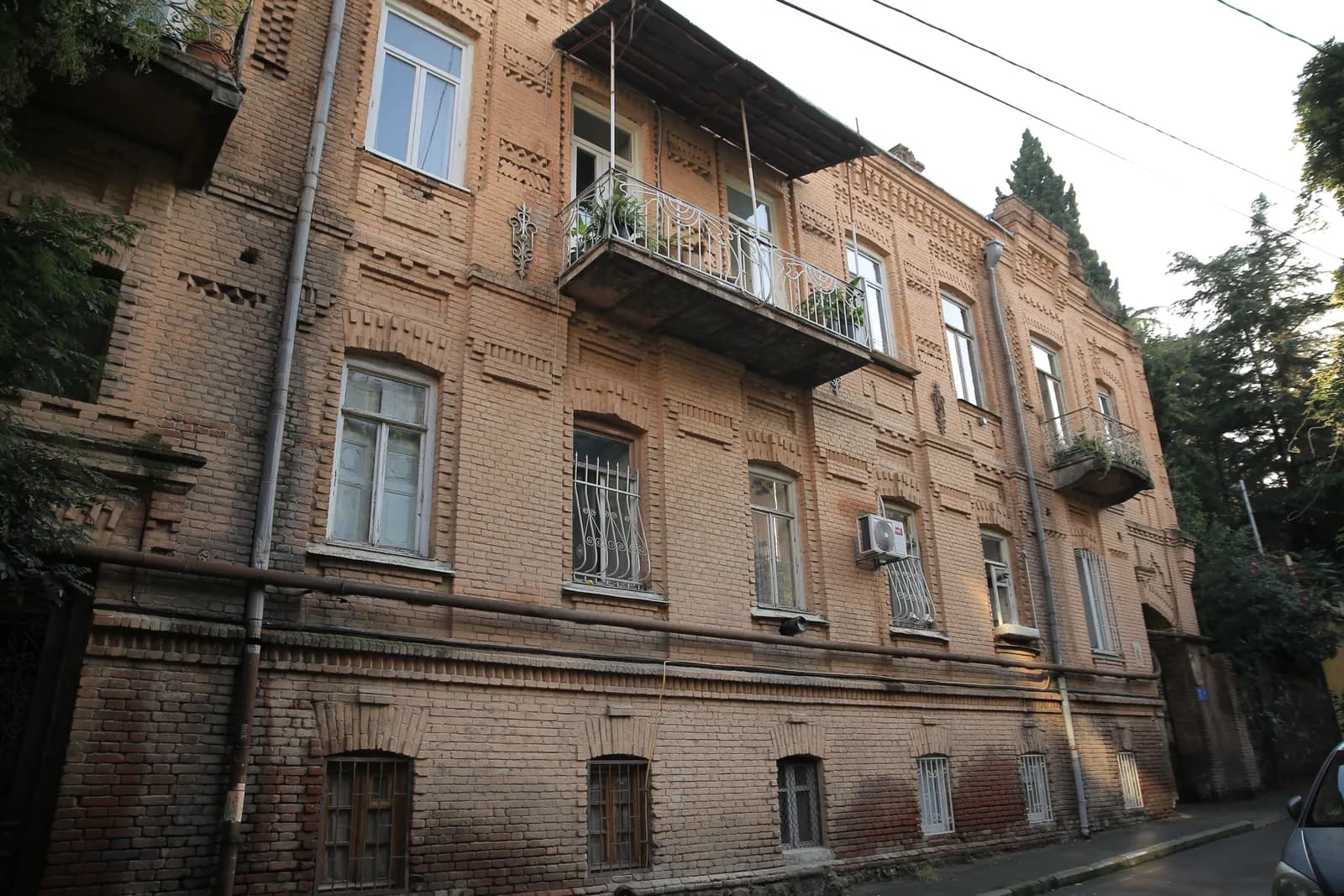 Brick facade of an 1893 residential house with a wrought iron balcony on Gizo Nishnianidze Street in Sololaki