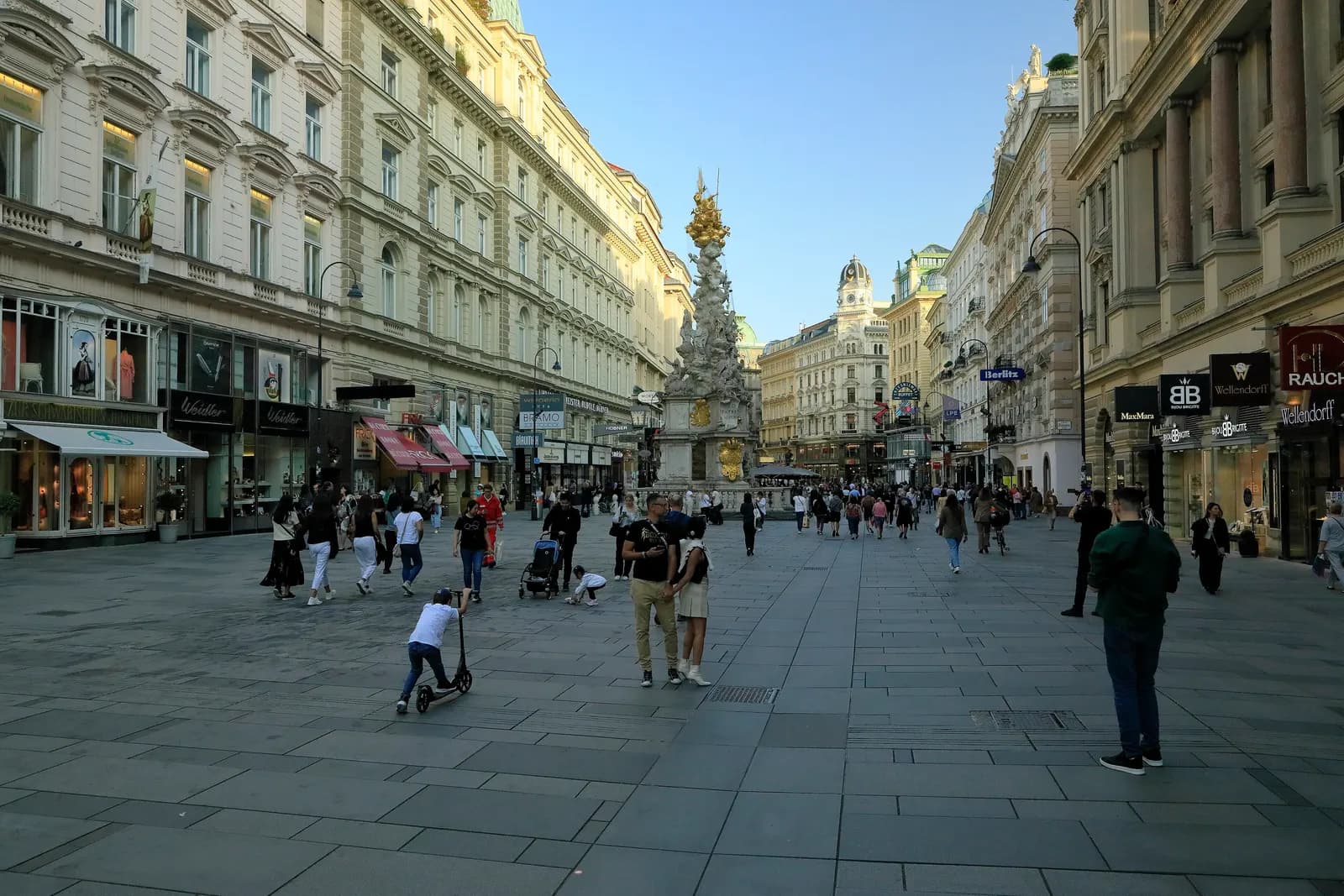 The Graben pedestrian street in the first district with the baroque plague column in the middle and people walking between the shopfronts
