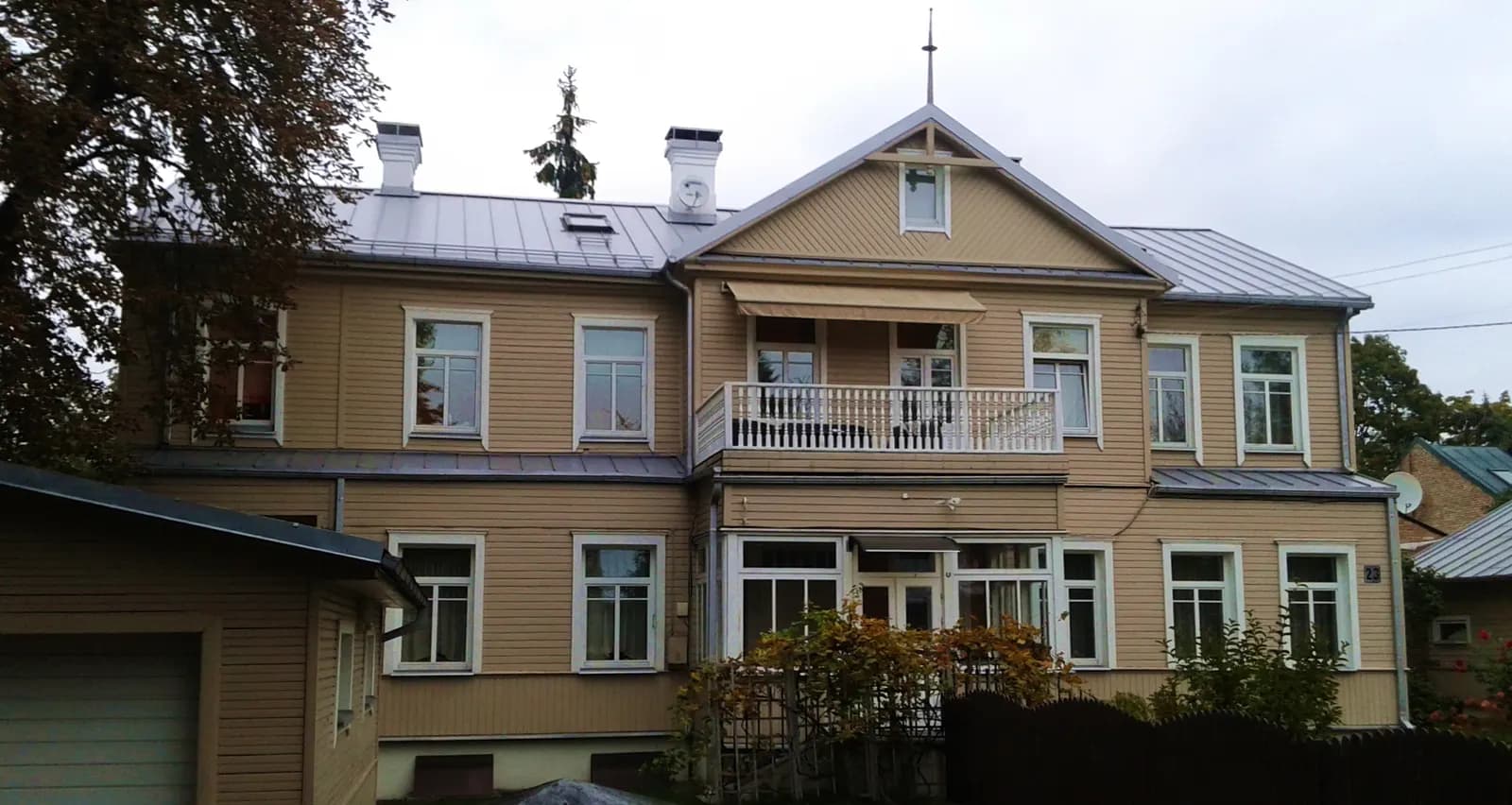 A two-storey wooden house with a balcony and a metal roof in Žvėrynas, Vilnius