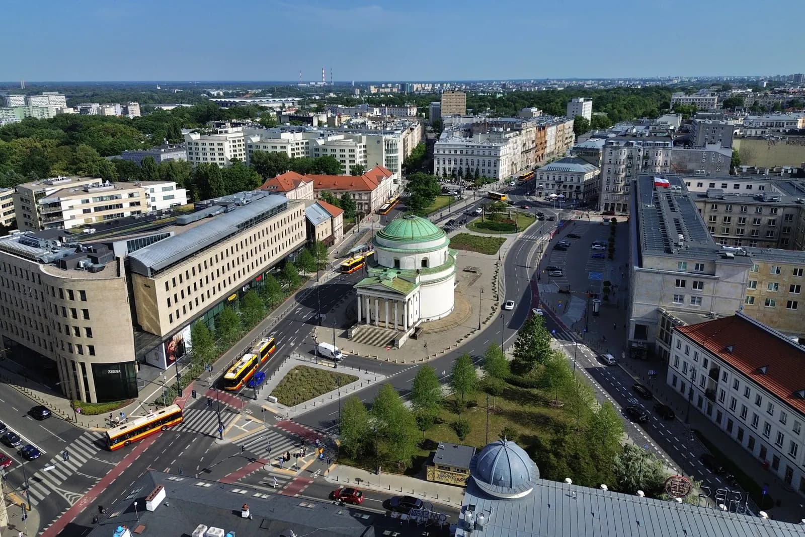 Aerial view of Plac Trzech Krzyży in central Warsaw, with the domed St Alexander's Church in a green square, streets and office buildings around it