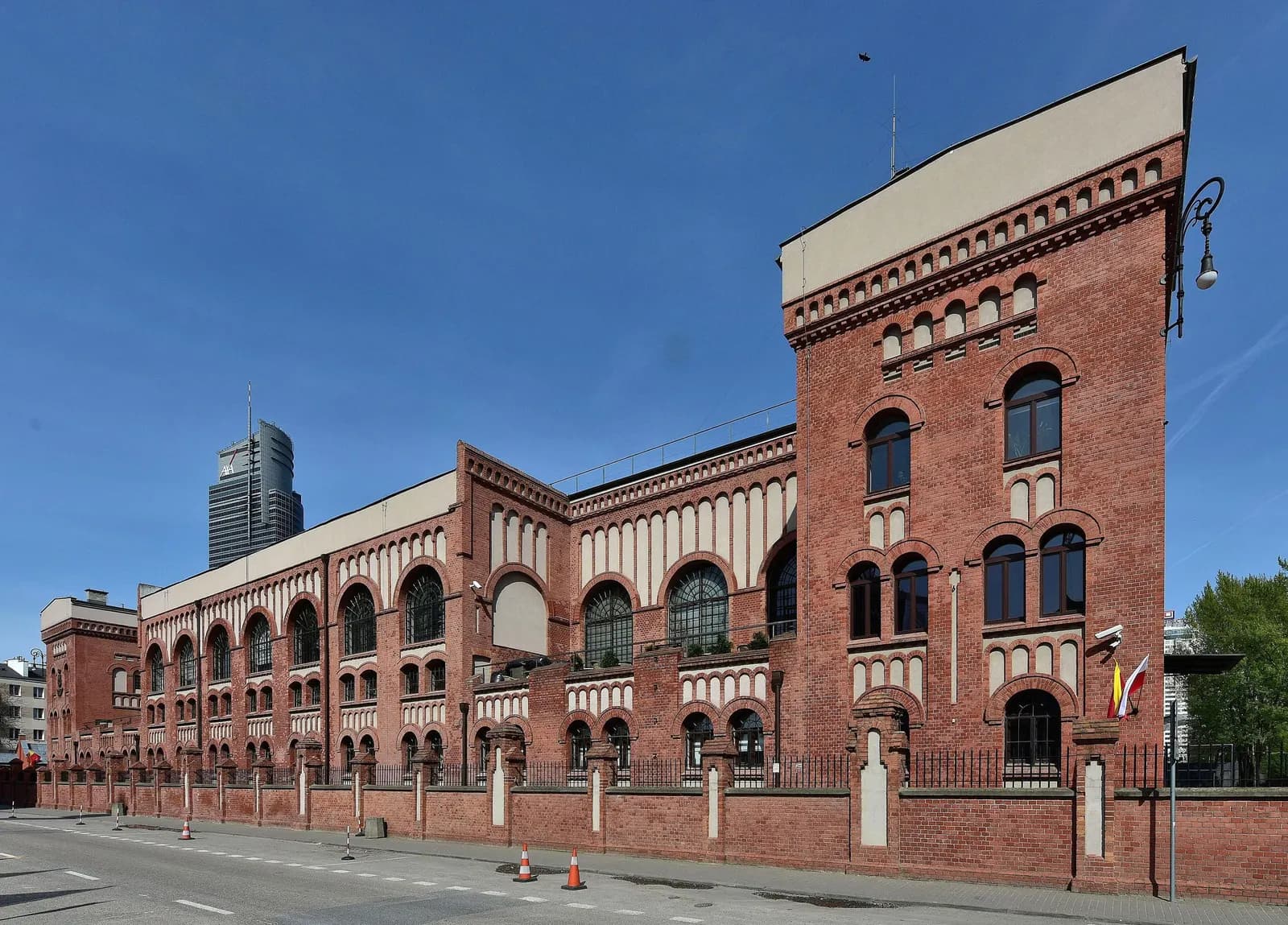 The red brick former tram power station that houses the Warsaw Rising Museum in Wola, with an office tower in the distance